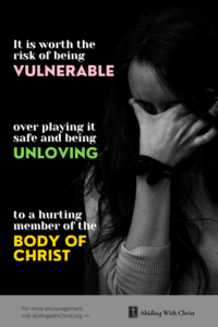 Link to Pinterest pin image of woman in the dark with hand over her face with text that reads "It is worth the risk of being vulnerable over playing it safe and being unloving to a hurting member of the body of Christ". 