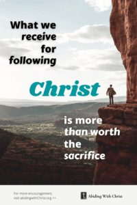 Link to Pinterest pin image of man standing on edge of a cliff overlooking a vast valley with text that reads "What we receive for following Christ is more than worth the sacrifice". 