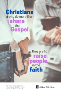 Link to Pinterest pin image of two people from the shoulder down standing across from each other holding Bibles with text that reads "Christians are to do more than share the Gospel, they are to raise people in the faith". 