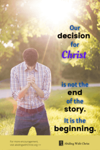 Link to Pinterest pin image of young man in a wooded area bowing with fingers interlaced with text that reads "Our decision for Christ is not the end of the story. It is the beginning. 