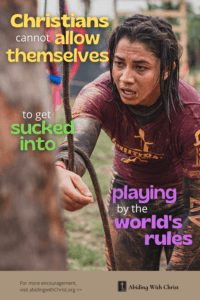 Link to Pinterest pin image of a muddy, exhausted woman who appears to be competing in an extreme obstacle course with text that reads "Christians cannot allow themselves to get sucked into playing by the world's rules". 