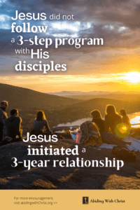 Link to Pinterest pin image of a group of people sitting on a hillside as the sun sets, with text that reads "Jesus did not follow a 3 step program with His disciples. Jesus initiated a 3 year relationship".