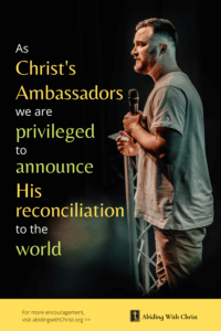 Link to Pinterest pin image of man speaking at a podium holding a microphone with text that reads "As Christ's ambassadors we are privileged to announce His reconciliation to the world". 