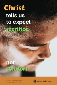 Link to Pinterest pin image of young man's face, focusing on the sweat on his forehead, with text that reads "Christ tells us to expect sacrifice, not comfort".